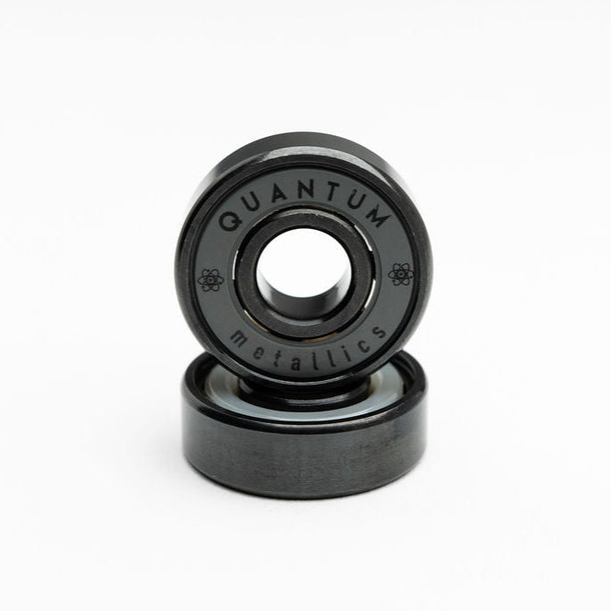 Two black bearings with 'Quantum Metallics' branding on a white background